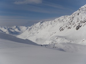 Our party makes its way up a slope on the first clear morning in five days. Base camp is in the background.